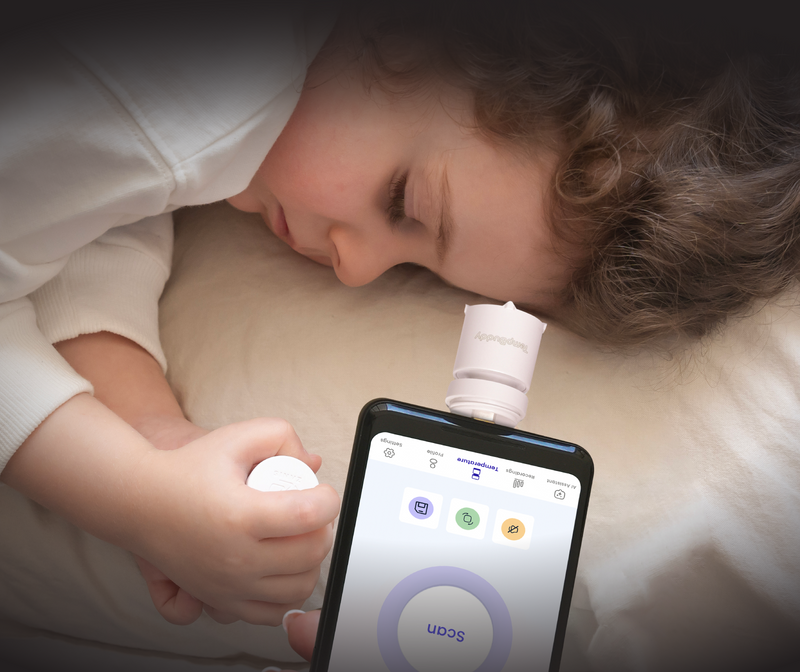 A parent taking a sleeping child’s forehead temperature with TempBuddy in Silent Mode