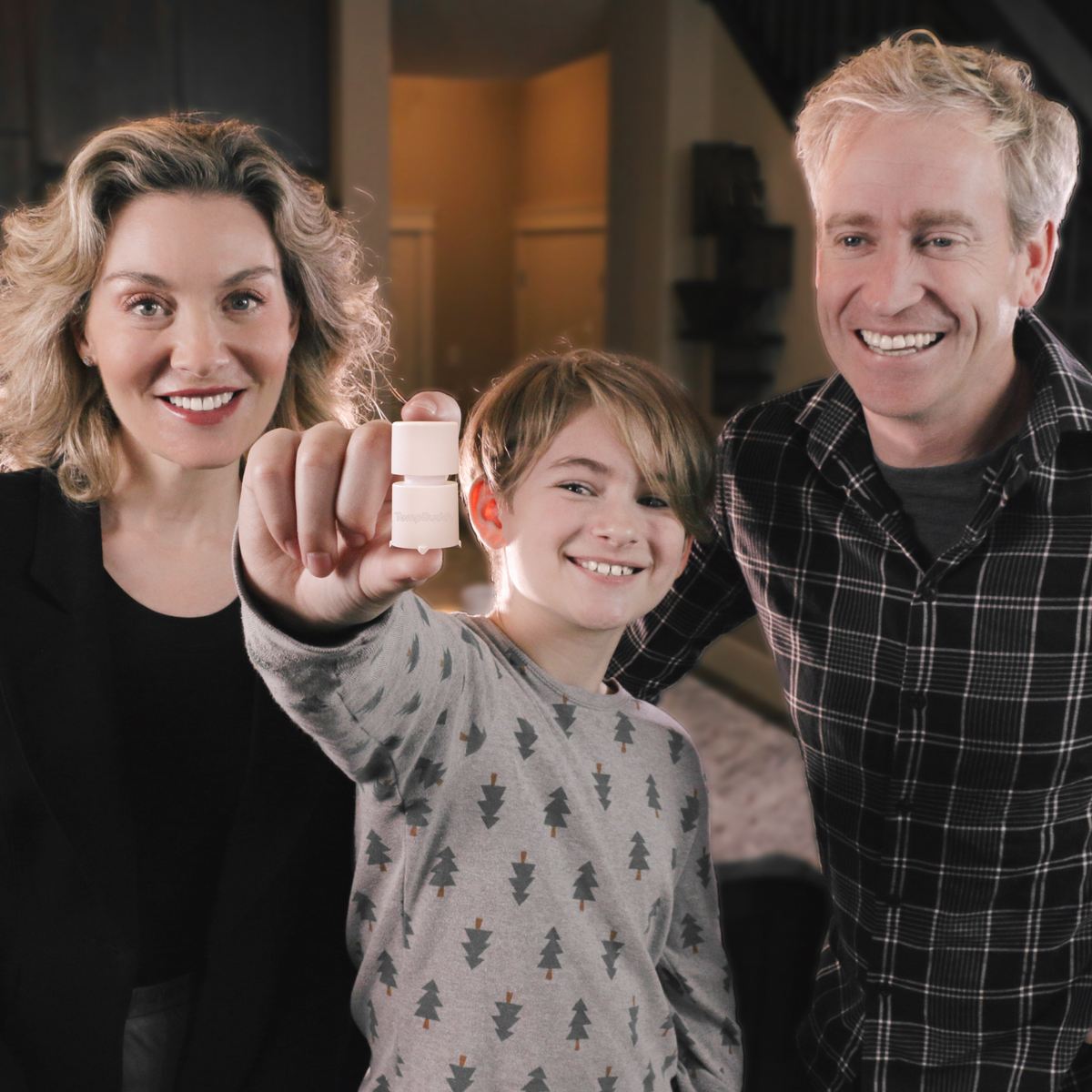 A family holding up a TempBuddy device